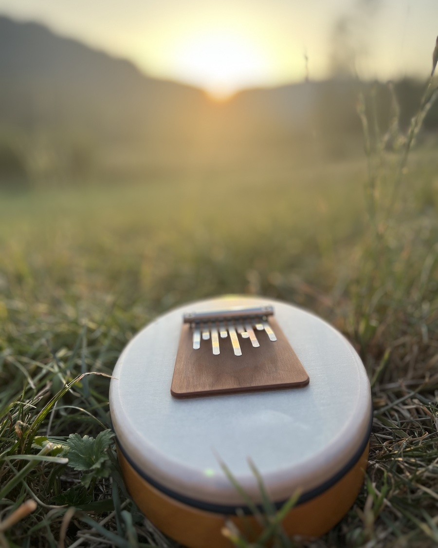 Kalimba im Gras bei Sonnenuntergang - die Frequenzen der Musik